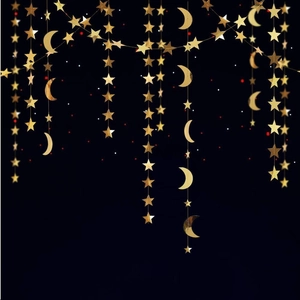 Close-up of gold glitter star and moon paper banners for festive party decorations