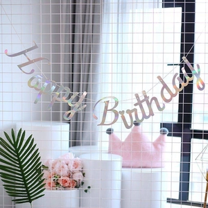 Iridescent Happy Birthday banner hanging on a grid wall for elegant party decoration