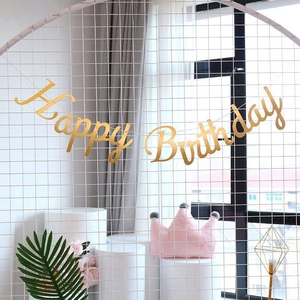 Golden glitter Happy Birthday banner hanging on a white grid for party decoration