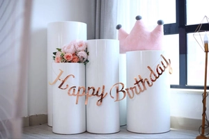 Close-up of rose gold Happy Birthday banner hanging over white pedestal display