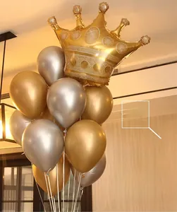Macro shot of metallic chrome balloons and a golden crown foil balloon for party decor