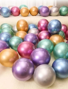 Close-up of assorted metallic latex balloons in vibrant colors on soft plush surface
