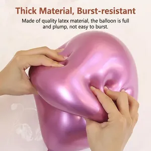 Thick metallic rose pink latex balloon being squeezed to show high elasticity and durability