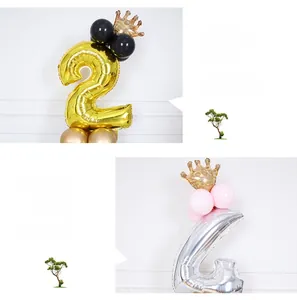 Detail of gold number 2 and silver number 4 foil balloons with crown topper for parties