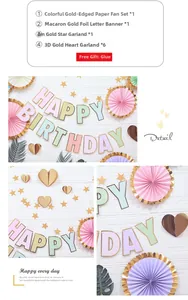 Détail du kit de fête macaron avec éventails dorés, bannière d'anniversaire et guirlandes