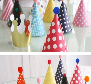 Macro detail of assorted colorful party hats with pom-poms and golden crown designs