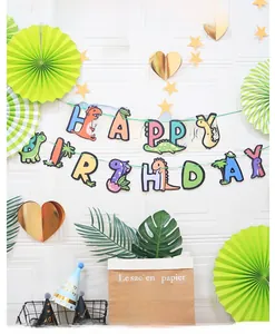 Close-up of dinosaur happy birthday banner with matching party hats and decorations
