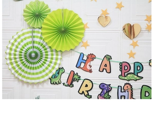 Detail of cartoon dinosaur Happy Birthday paper banner with decorative paper fans and stars