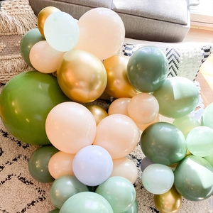 Close-up of olive green, cream, and gold balloon arch kit for boho party decoration