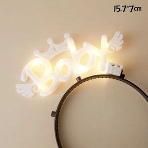 Macro shot of LED Baby headband with crown and wings on a warm beige background
