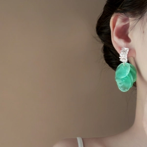 Dettaglio di eleganti orecchini a nappa in conchiglia verde con ago in argento e zirconi