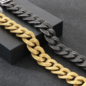 Nahaufnahme von breiten, texturierten Panzerarmbändern aus Edelstahl in Gold und Schwarz.
