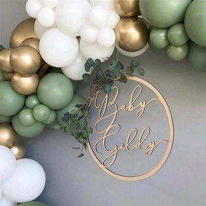 Avocado green balloon arch set with custom wooden Baby Goldy sign and eucalyptus leaves
