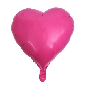 Macro view of a metallic rose pink heart-shaped aluminum foil balloon for party decor