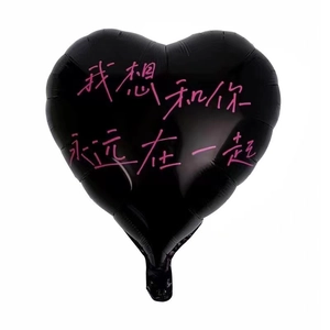 Matte black heart-shaped foil balloon with pink lettering on a clean white background