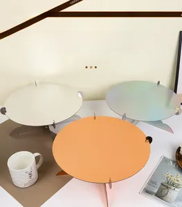 Detailed view of single-tier cardboard cake stands in cream and holographic colors