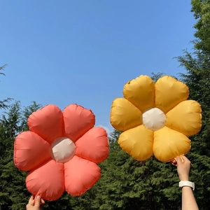 Detail of pink and yellow daisy foil balloons against a blue sky for party decor