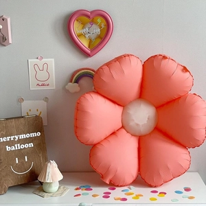 Pink and white daisy foil balloon for party decor on a cozy tabletop setting