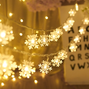 Close-up of snowflake LED fairy lights with warm white glow and transparent wire