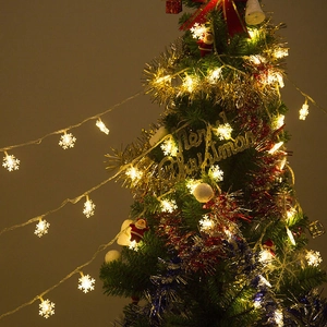 Warm white snowflake LED string lights glowing on a decorated Christmas tree for holidays