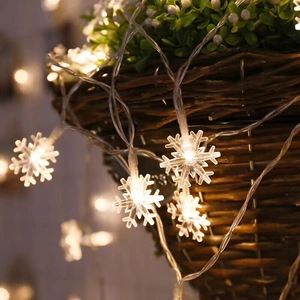 Close-up of warm white LED snowflake string lights on a woven basket for home decor