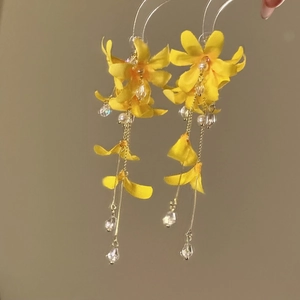 Close-up of ethereal yellow floral tassel earrings with pearl and crystal beads