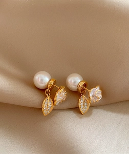 Detail view of elegant camellia stud earrings featuring pearls and zircon leaves.