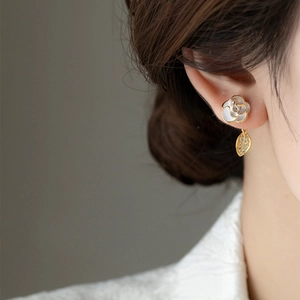 Detailed view of elegant camellia stud earring with pearl and zircon leaf charm