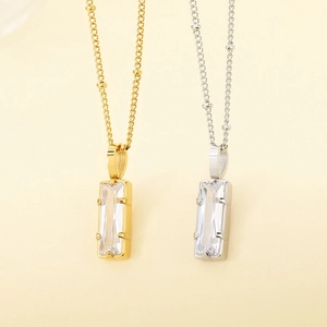 Gros plan de colliers minimalistes en acier inoxydable avec pendentifs en cristal.