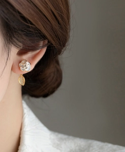 Elegant camellia flower stud earrings with pearl and zircon leaf dangle on model