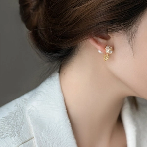 Side view of elegant camellia earrings with pearls and gold leaf detail on ear