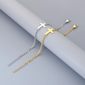 Detailed view of minimalist gold and silver stainless steel cross bracelets on a chain.