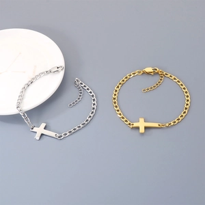 Close-up of minimalist stainless steel curb chain bracelets with horizontal cross charm