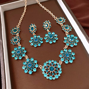 Close-up of elegant vintage turquoise rhinestone flower necklace and earrings set in box