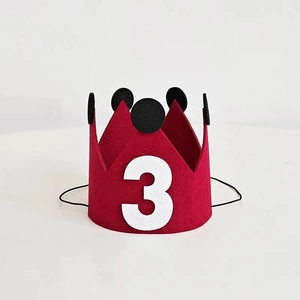 Detail view of red felt birthday crown with number 3 and black pompom for toddler party