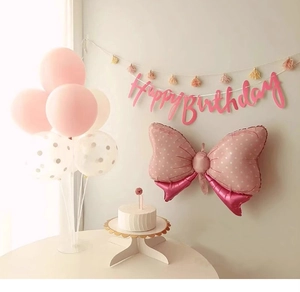 Close-up of pink Happy Birthday banner with bow balloon and party decoration set