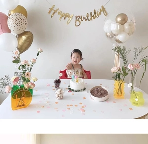 Golden Happy Birthday banner with balloons and acrylic vase for kids party decor