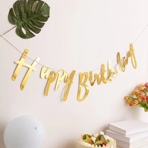 Golden mirror Happy Birthday banner hanging on wall with party cakes and balloons decor