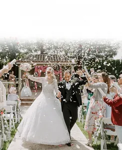 Romantic wedding scene with white butterfly confetti falling around a happy couple