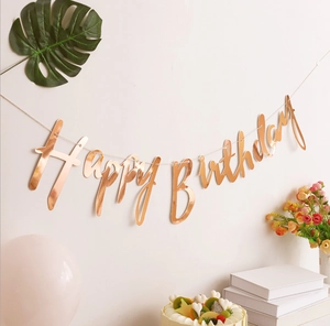 Close-up of rose gold Happy Birthday banner with metallic finish for party decoration
