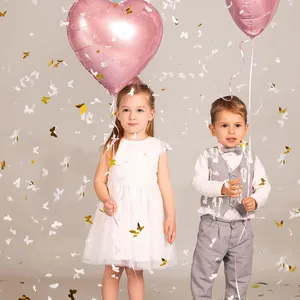 Detail of white lace princess dress and grey vest set with gold butterfly confetti