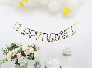 Dettaglio dello striscione Happy Birthday dorato a specchio in un set per feste