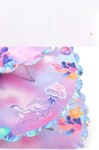 Close-up of laser holographic mermaid theme tiered cupcake stand with sea life patterns