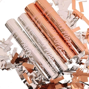 Rose gold and silver party poppers with metallic confetti for celebration photography