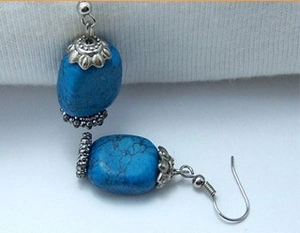 Detail of vintage silver earrings with blue turquoise stones and ethnic floral carvings
