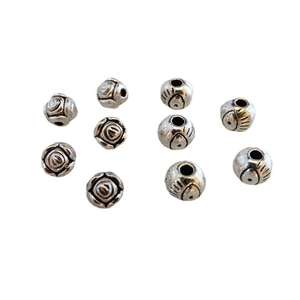 Makroaufnahme von Vintage-Silberperlen mit Blumen- und Augenmuster für DIY-Schmuck