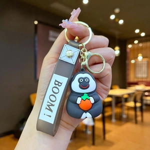 Cute gray gorilla silicone keychain with orange fruit and brown Boom! printed strap