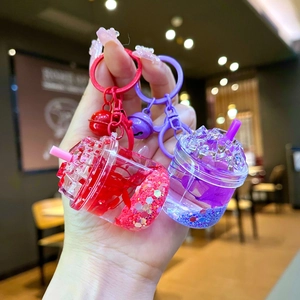 Close-up of handmade bubble tea keychain with colorful glitter liquid and flower charms