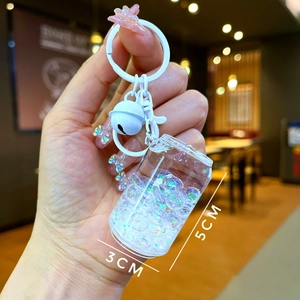 Detailed view of luminous cola can keychain with colorful beads and white bell accessory