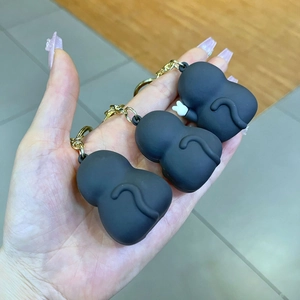 Detailed close-up of three black cartoon monkey keychains with white glove accessories